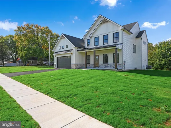 a view of a house with a big yard and large trees