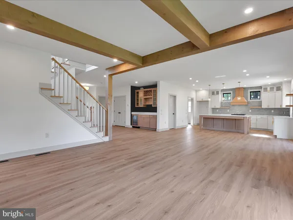 a view of a kitchen with wooden floor and an empty space