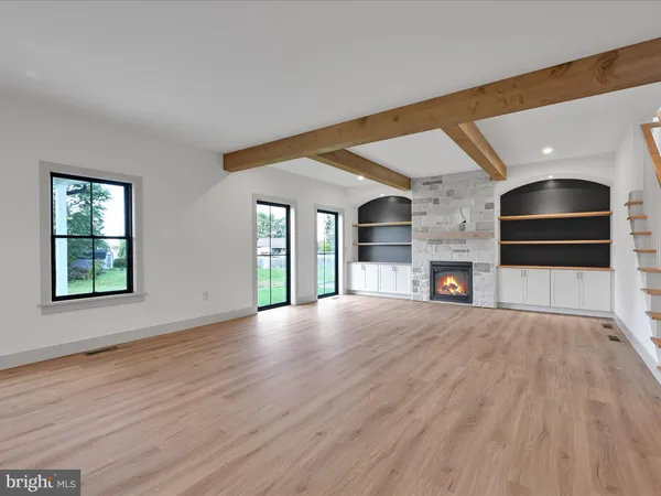 a view of empty room with wooden floor and fireplace
