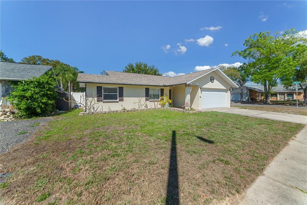 8715 Huntsman Lane Port Richey, FL 34668 - Photo 2 of 54 a front view of a house with a yard and trees