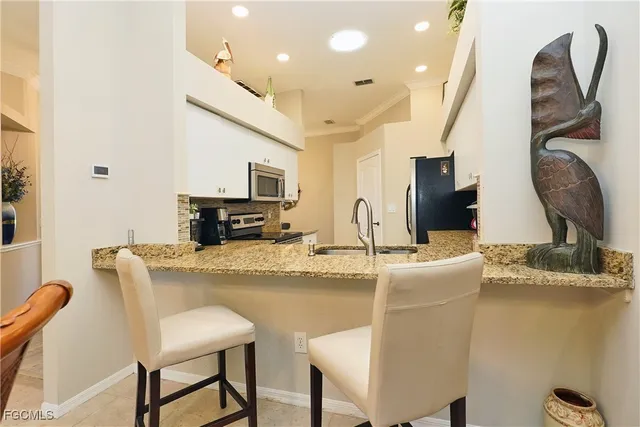 a kitchen with stainless steel appliances granite countertop a sink and a refrigerator