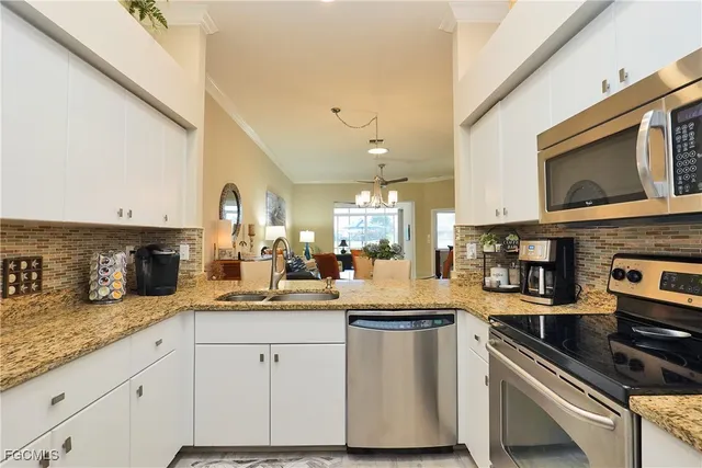 a kitchen with granite countertop a sink stainless steel appliances and cabinets