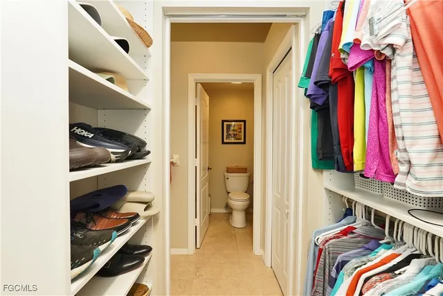 a view of walk in closet with clothes and shoes