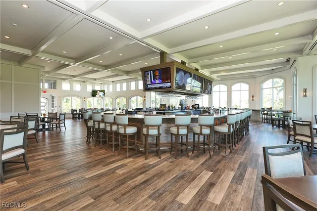 a room with lots of furniture and view of kitchen appliances