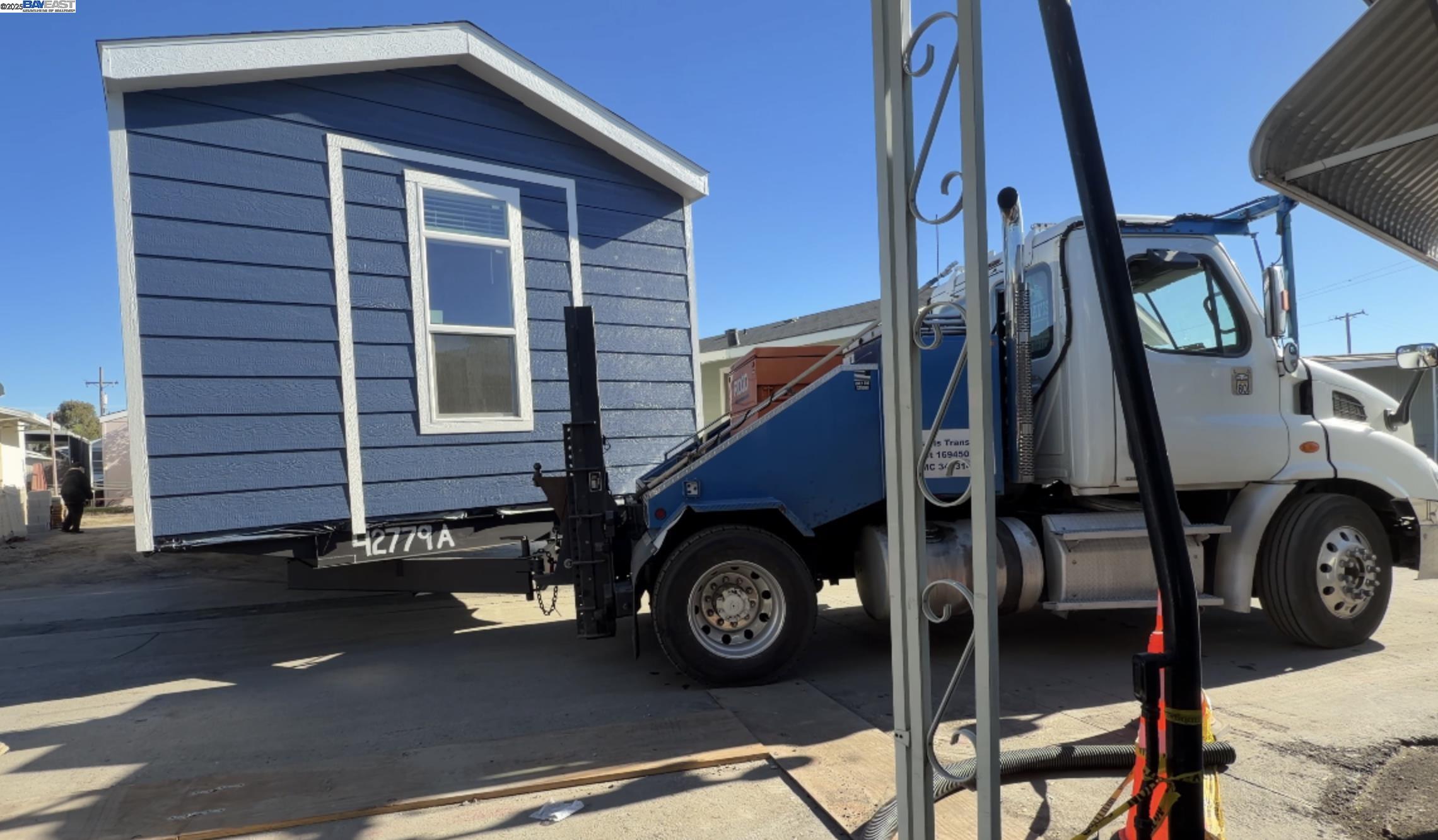 a view of a house with a car park side of road