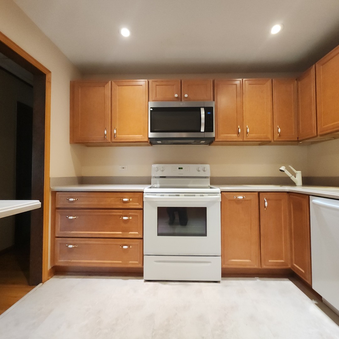 4605 West 84th Place Chicago, IL 60652 - Photo 13 of 31 a kitchen with granite countertop white cabinets and stainless steel appliances