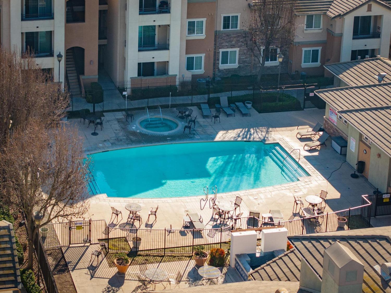 1360 Shady Lane, Unit 1022 Turlock, CA 95382 - Photo 16 of 16 a view of a patio with table and chairs under an umbrella