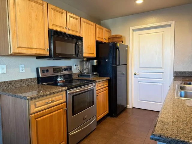 a kitchen with stainless steel appliances granite countertop a stove microwave and refrigerator