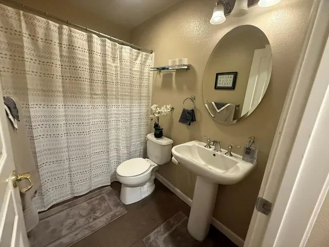 a bathroom with a sink mirror toilet and shower