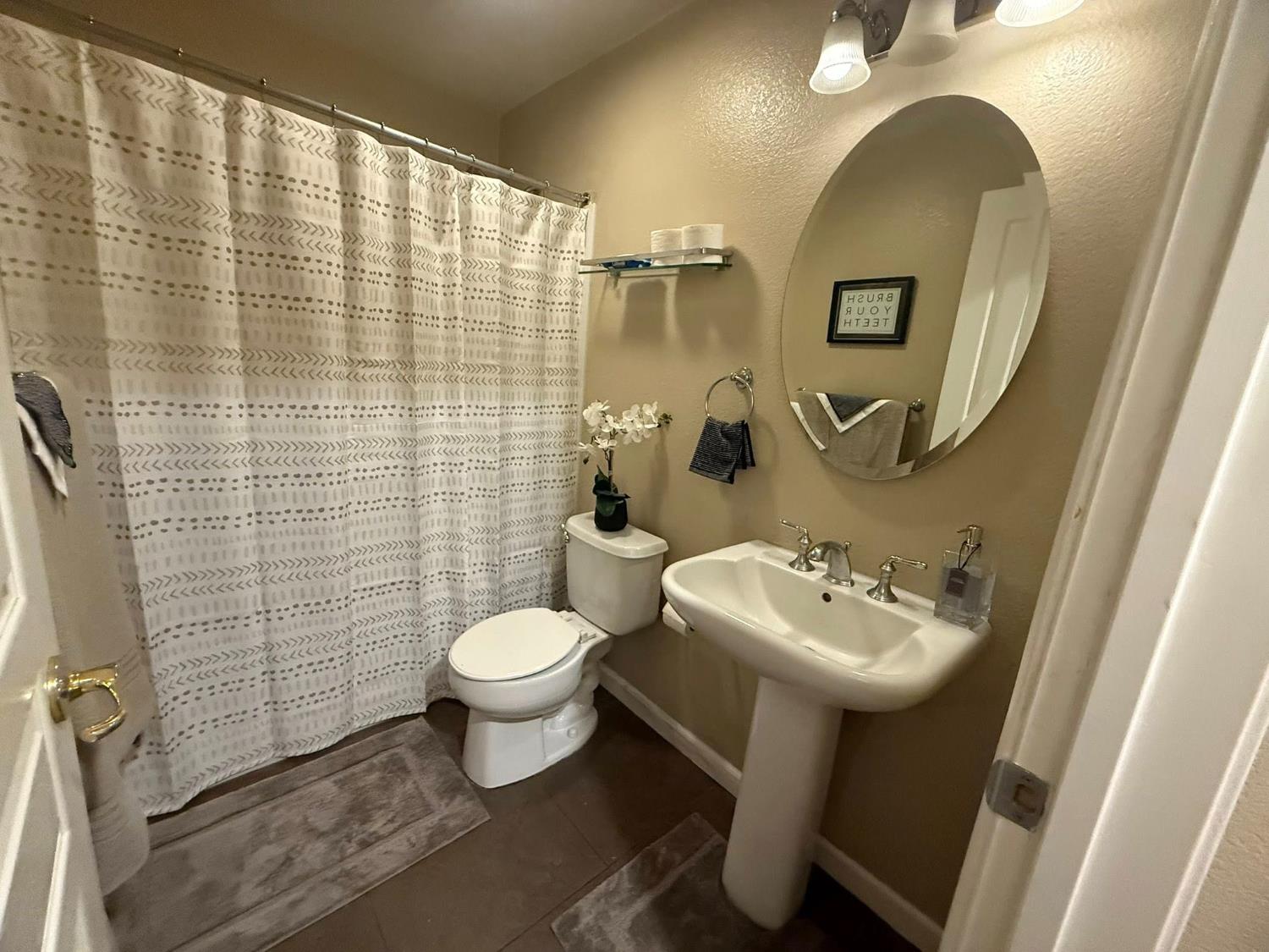 1360 Shady Lane, Unit 1022 Turlock, CA 95382 - Photo 5 of 16 a bathroom with a sink mirror toilet and shower
