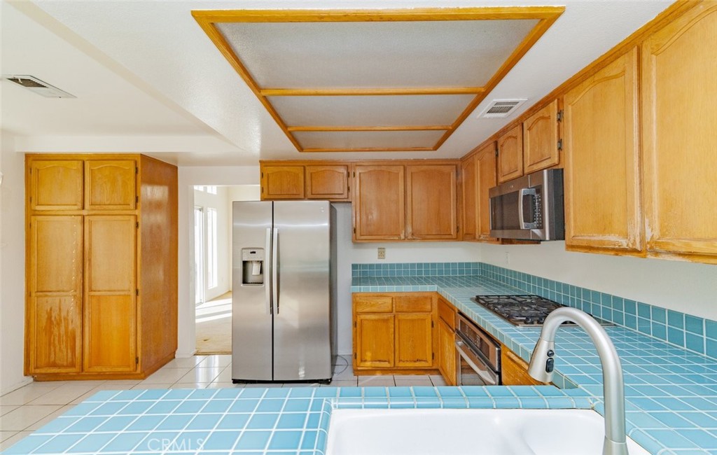 2038 Ridgeline Avenue Vista, CA 92081 - Photo 12 of 32 a kitchen with stainless steel appliances granite countertop a refrigerator and a sink