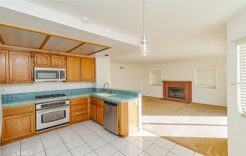 2038 Ridgeline Avenue Vista, CA 92081 - Photo 13 of 32 a kitchen with stainless steel appliances granite countertop a sink and cabinets