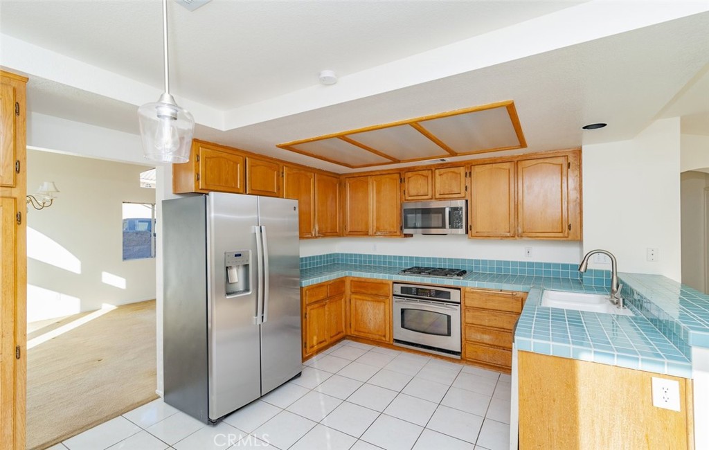 2038 Ridgeline Avenue Vista, CA 92081 - Photo 14 of 32 a kitchen with stainless steel appliances granite countertop a refrigerator and a sink