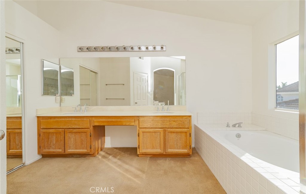 2038 Ridgeline Avenue Vista, CA 92081 - Photo 21 of 32 a spacious bathroom with a tub sink and mirror