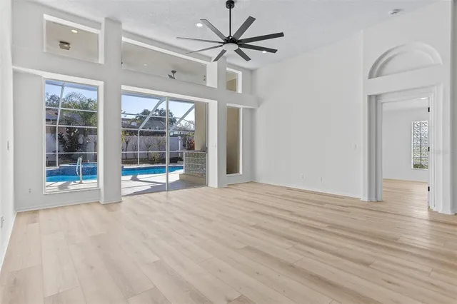 a view of an empty room with a window and a kitchen