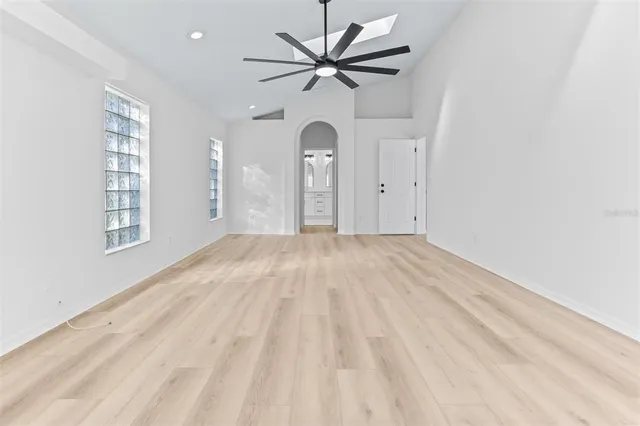 a view of empty room with wooden floor and fan