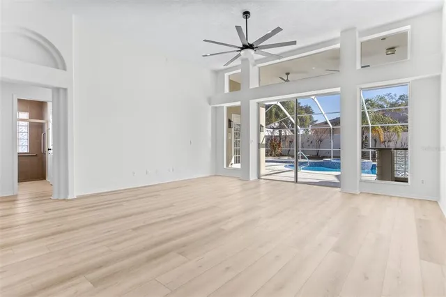 a view of an empty room with a window and wooden floor