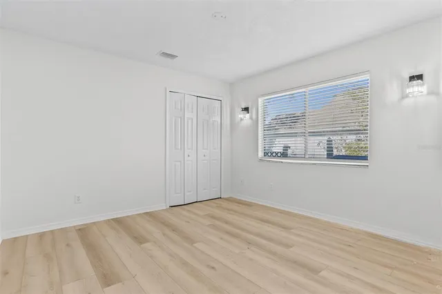 a view of empty room with wooden floor