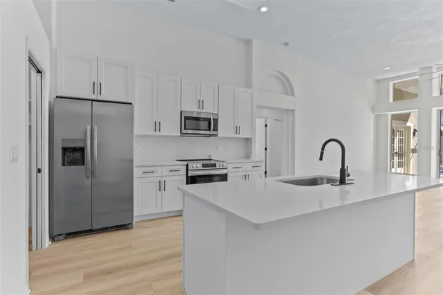 a kitchen with white cabinets and stainless steel appliances