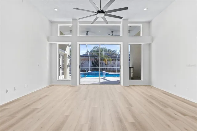 an empty room with windows and fan