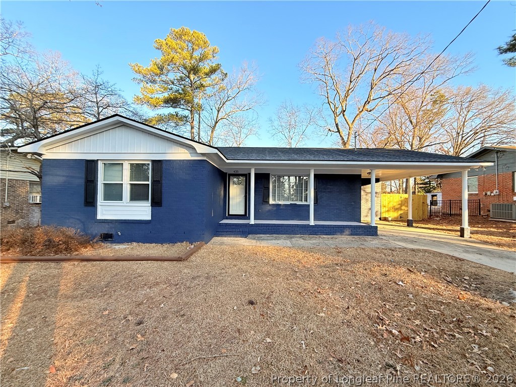 a front view of a house with a large tree
