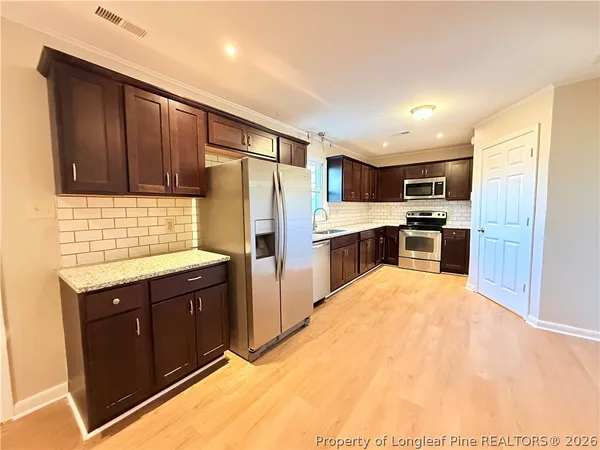 a kitchen with stainless steel appliances granite countertop a refrigerator and a sink