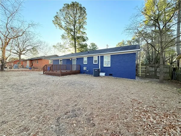 front view of a house with a yard and a large tree