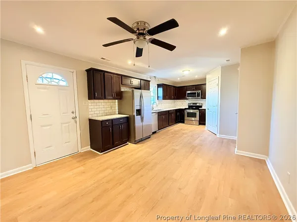 a kitchen with stainless steel appliances kitchen island granite countertop a refrigerator and a stove top oven