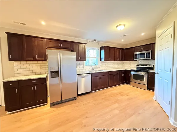 a kitchen with granite countertop appliances cabinets and a sink