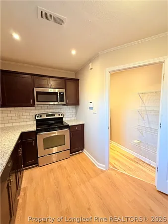 a kitchen with stainless steel appliances a stove a refrigerator and a sink