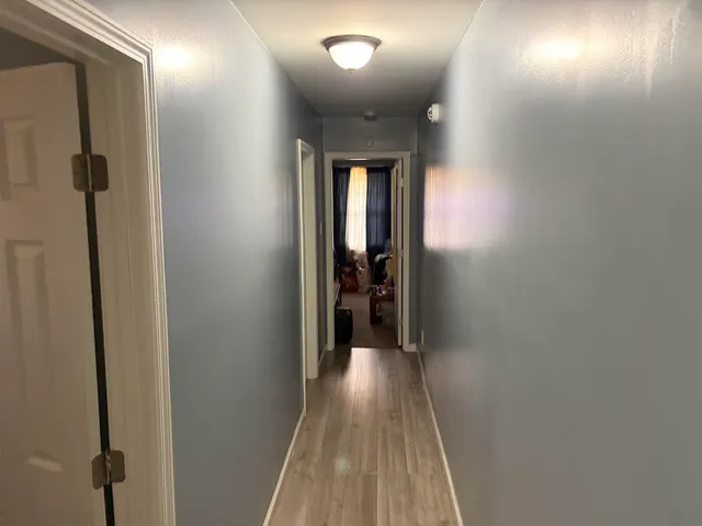 a view of a hallway with wooden floor