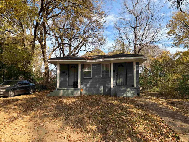 a front view of a house with yard furniture and garage
