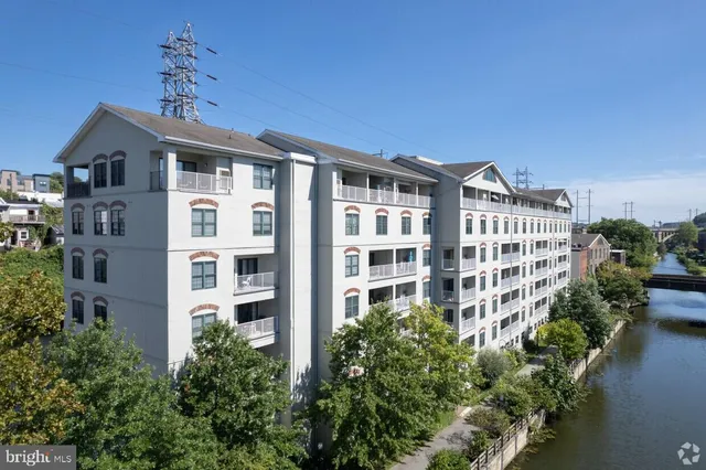 a front view of a building with balcony and garden