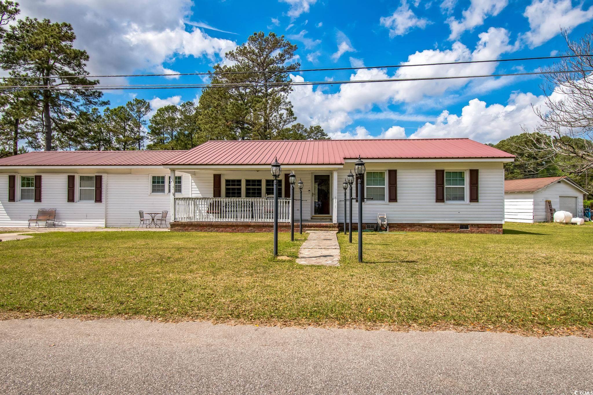 54 Juniper Place Georgetown, SC 29440 - Photo 2 of 11 Ranch-style home featuring a porch, a front lawn, a metal roof, and crawl space