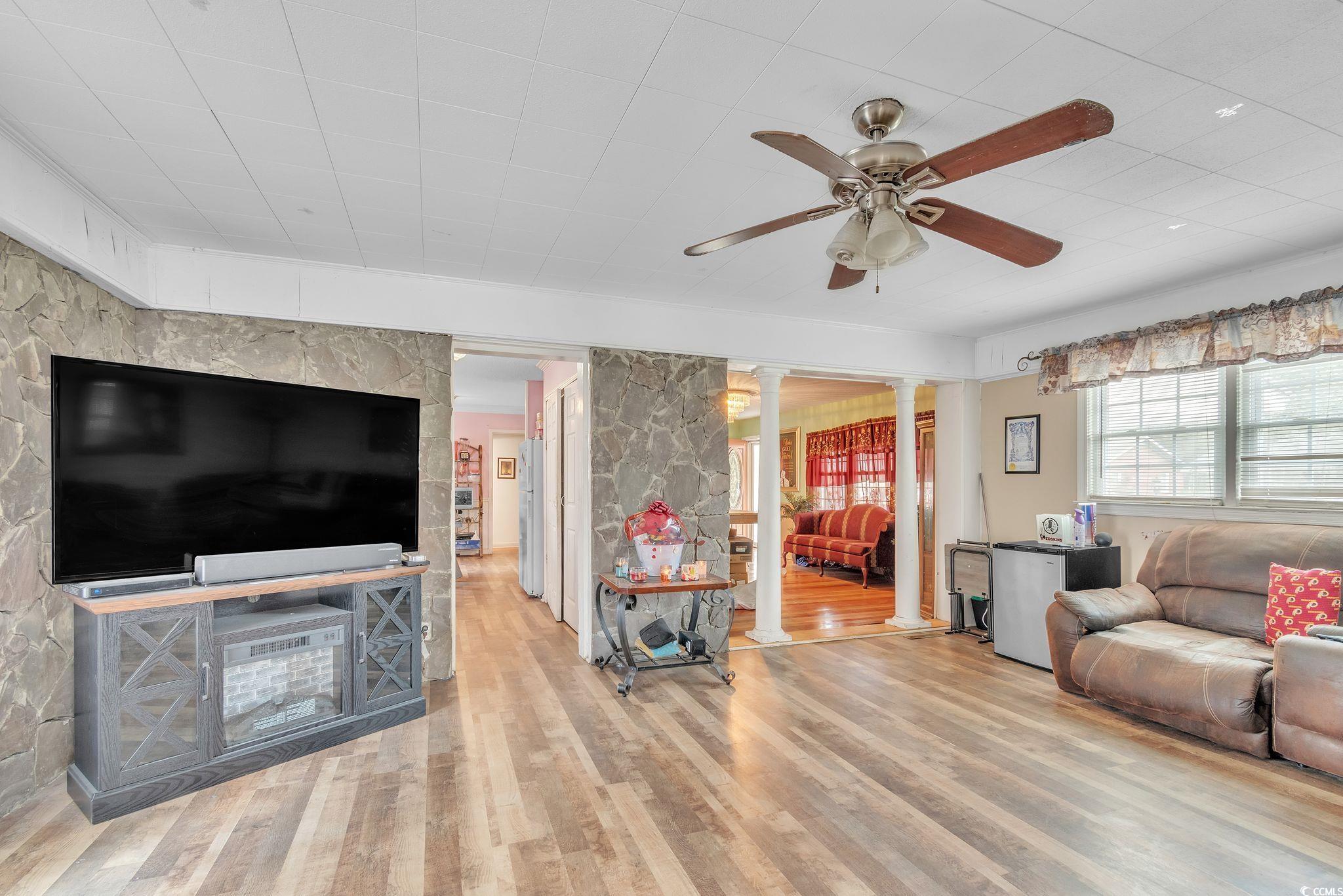 54 Juniper Place Georgetown, SC 29440 - Photo 3 of 11 Living area featuring ornate columns, light wood finished floors, and a ceiling fan