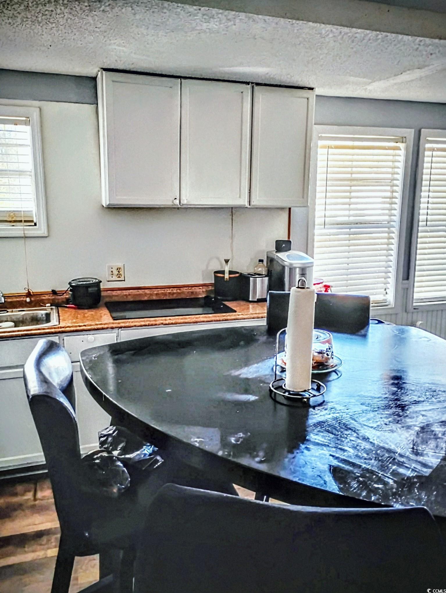 54 Juniper Place Georgetown, SC 29440 - Photo 4 of 11 Kitchen featuring a textured ceiling, white cabinets, dark countertops, and dark wood-style floors