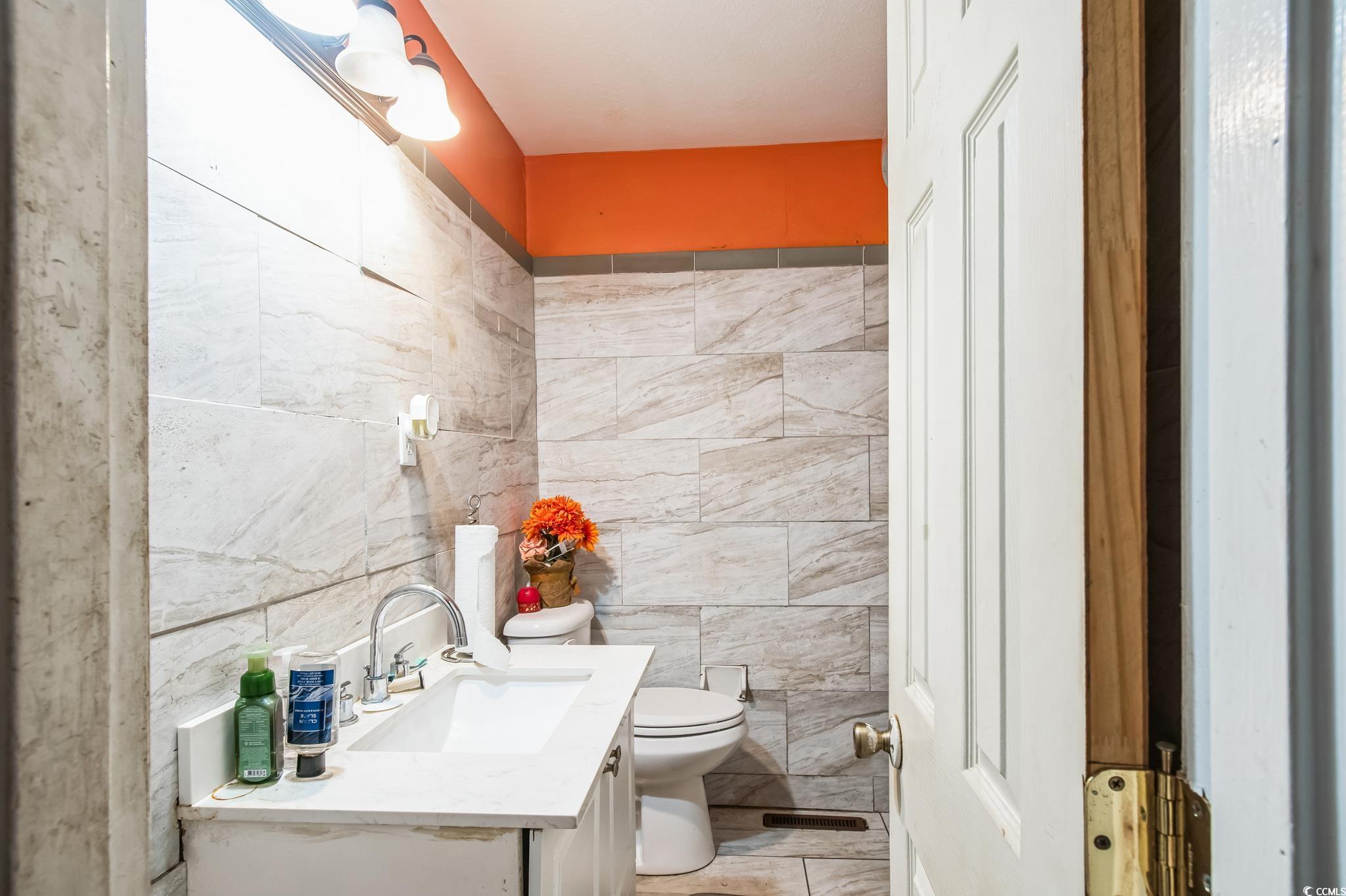 54 Juniper Place Georgetown, SC 29440 - Photo 8 of 11 Half bath with tile walls and vanity