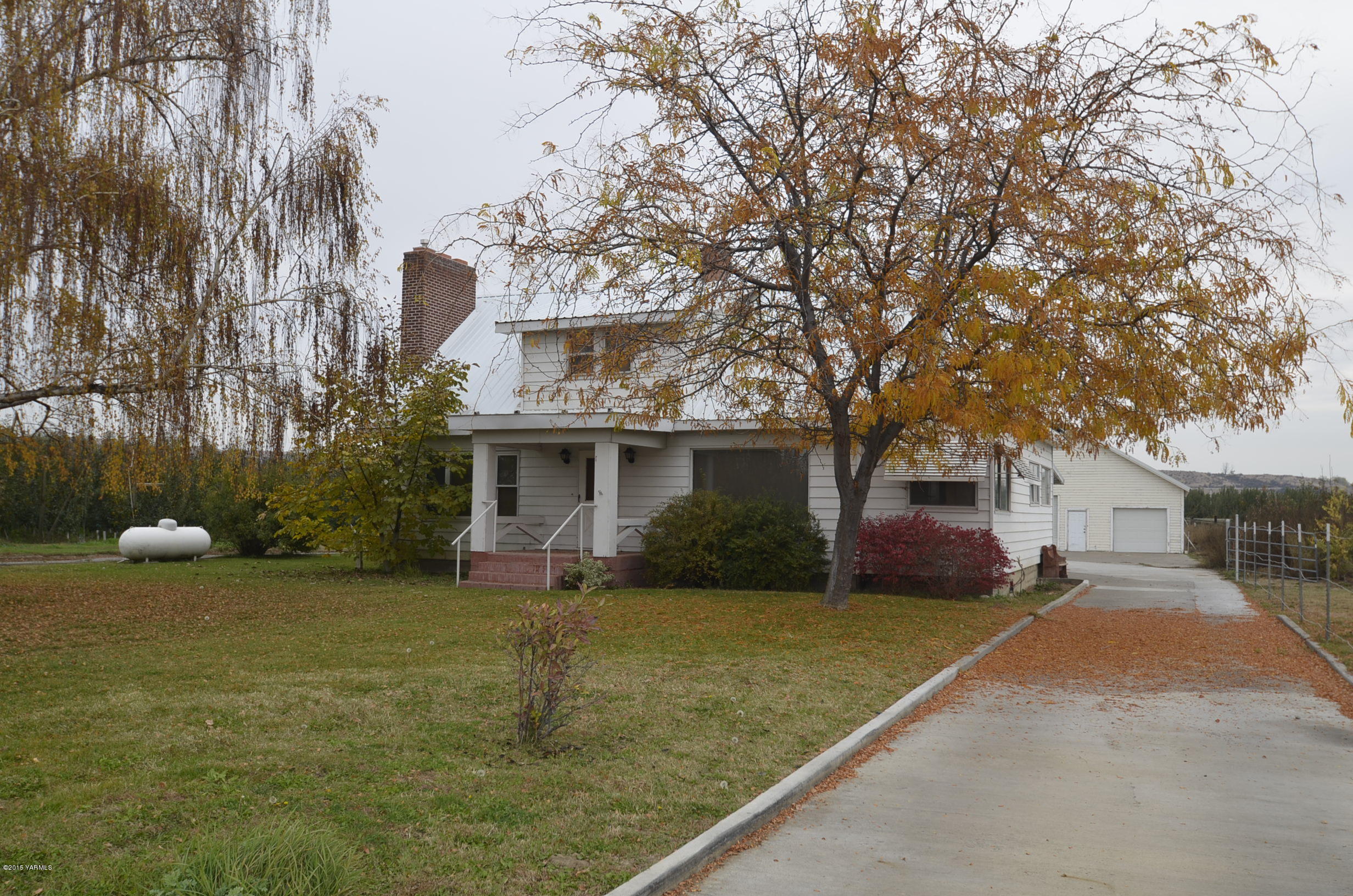 5131 Konnowac Pass Road Wapato, WA 98951 - Photo 3 of 18 a view of a house with backyard and a tree
