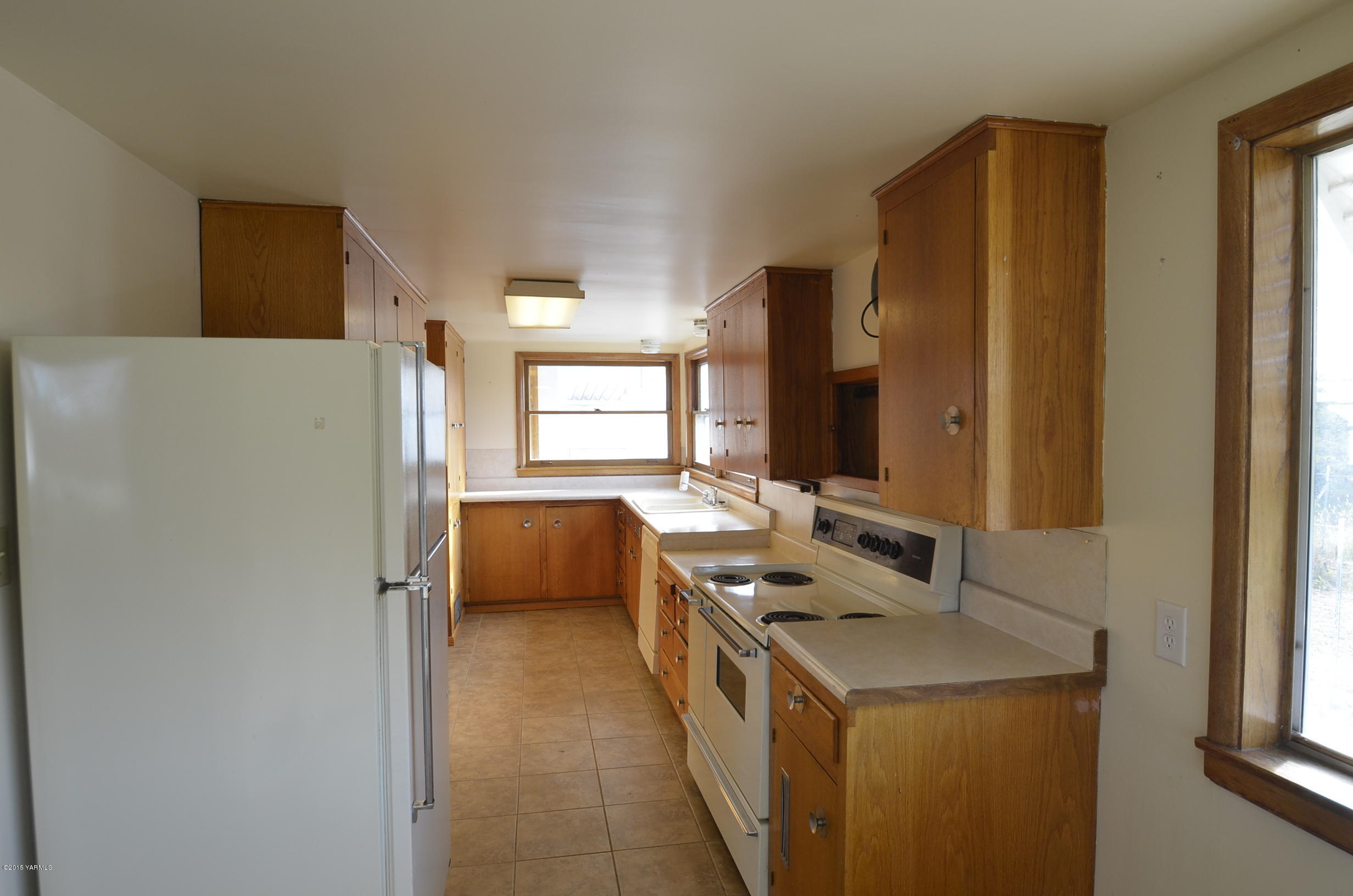 5131 Konnowac Pass Road Wapato, WA 98951 - Photo 8 of 18 a kitchen with a refrigerator and a stove top oven