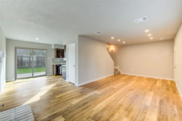 a view of empty room with wooden floor and entryway