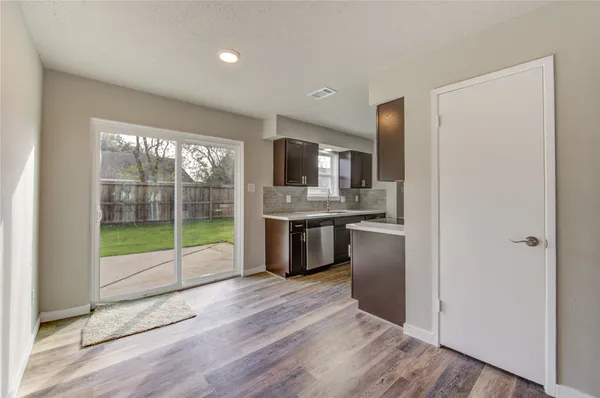 a kitchen with stainless steel appliances granite countertop a refrigerator a sink a stove a microwave and island with wooden floor