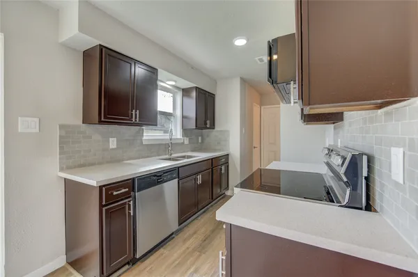 a kitchen with stainless steel appliances granite countertop a sink stove and refrigerator