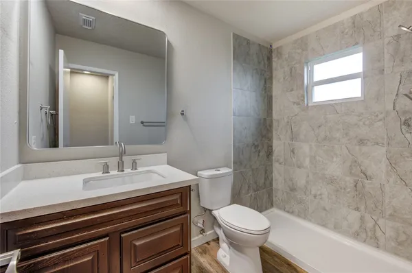 a bathroom with a sink a toilet a mirror and shower