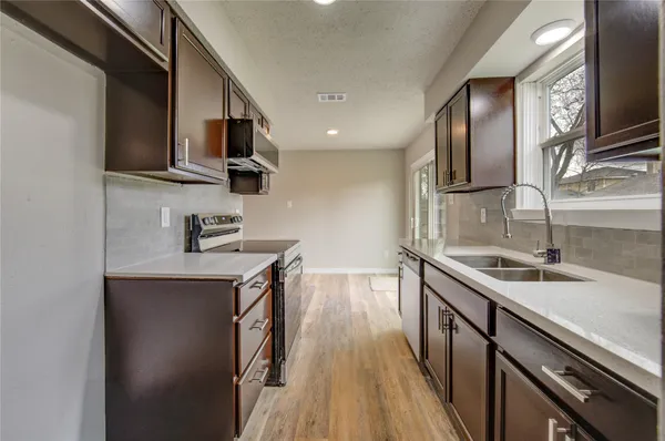 a kitchen with stainless steel appliances granite countertop a sink stove and microwave