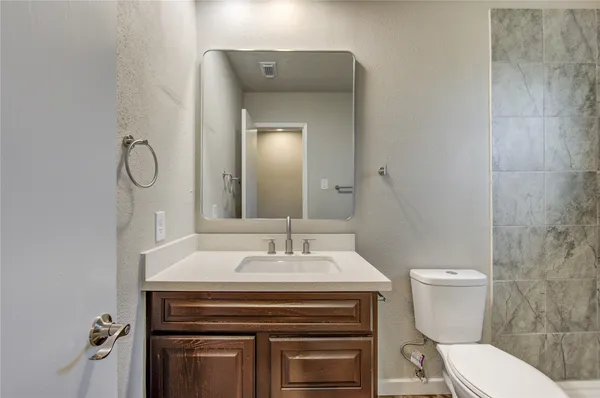a bathroom with a sink toilet and a mirror