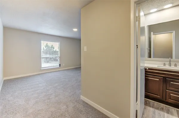 a view of an empty room and a kitchen