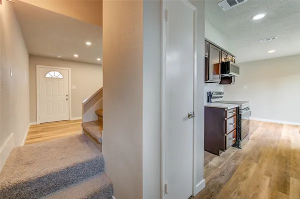 a view of a hallway with wooden floor and a living room