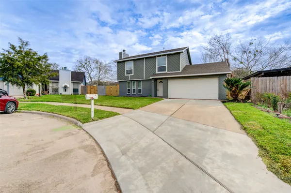 a front view of a house with a yard and trees