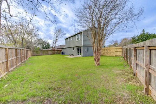 a view of a house with backyard and a tree