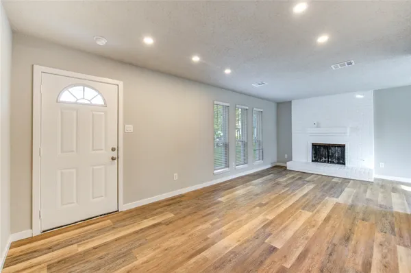 a view of an empty room with a window and fireplace